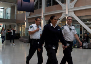 Three PalAmerican Security Guards Walking Through School