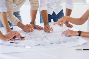 PalAmerican Individuals Writing on Blueprint